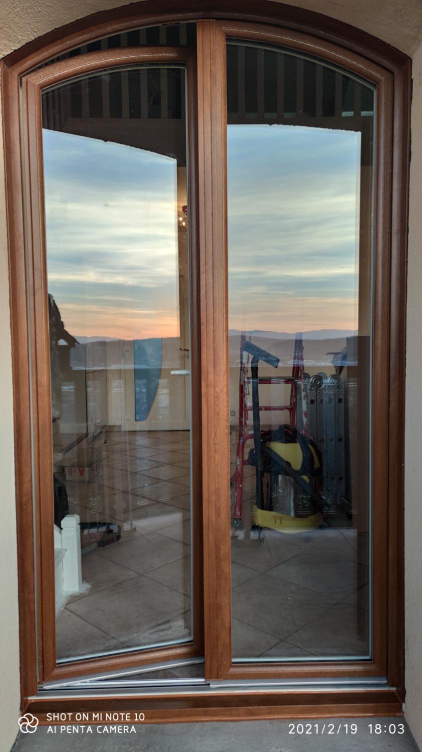 Porte-fenêtre cintrée aspect bois, reflet du ciel