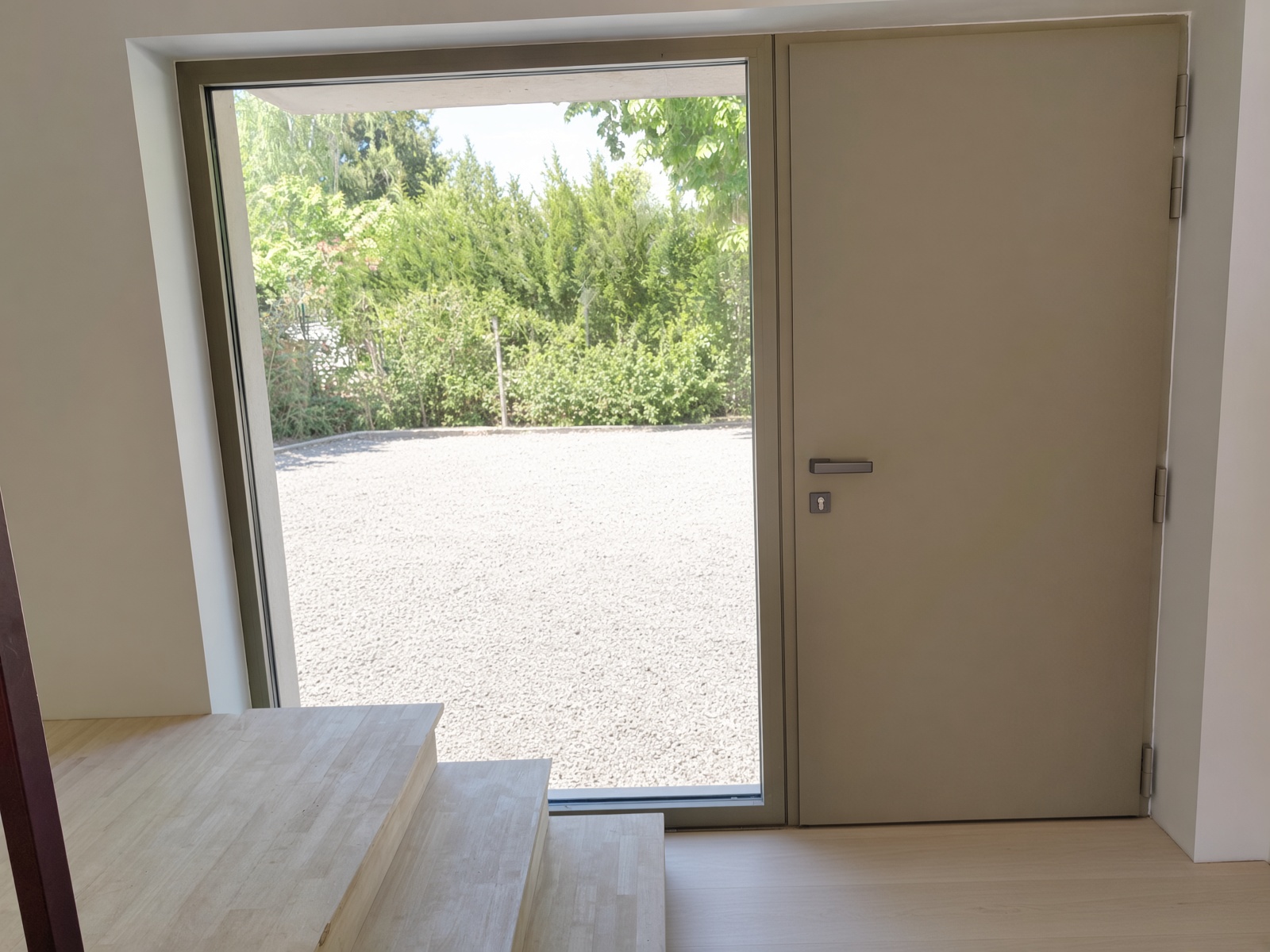 Porte d’entrée aluminium vue du hall, fixe vitrée à gauche