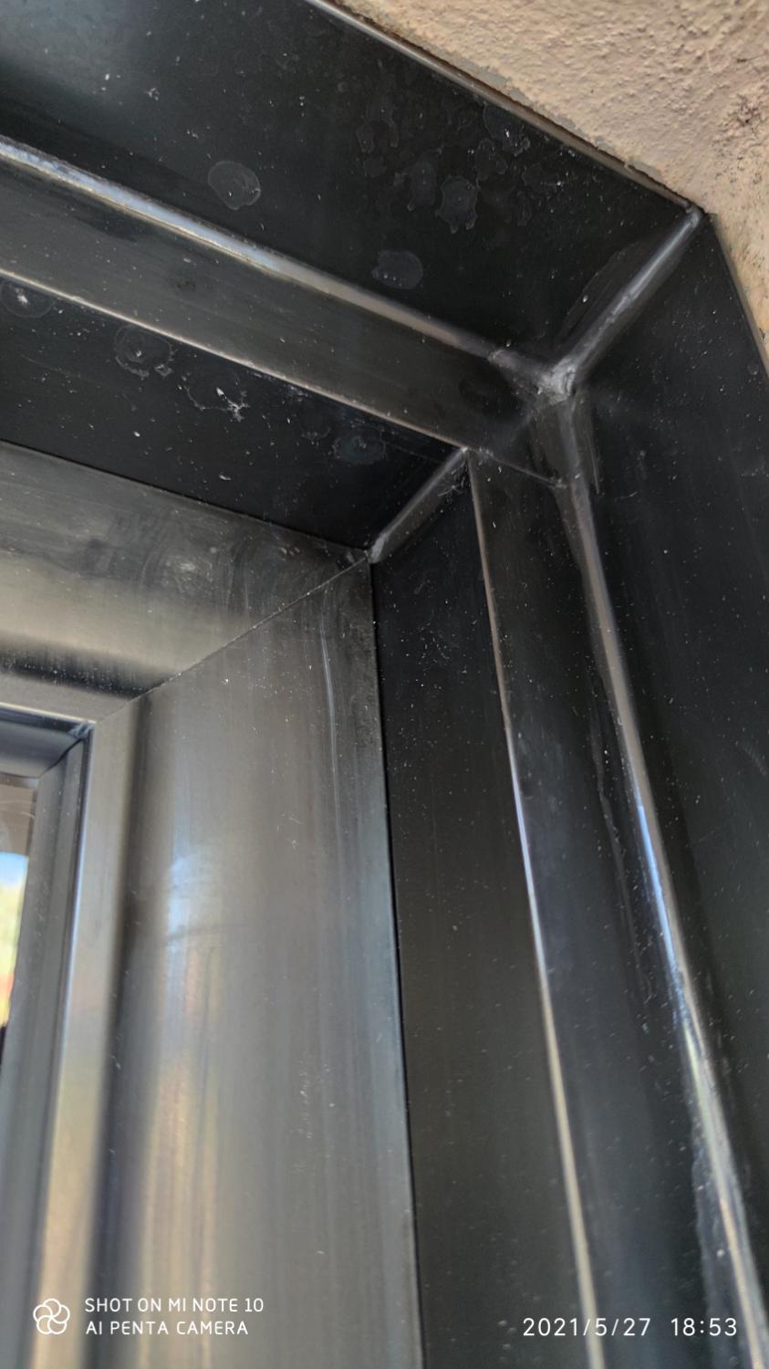 Angle d’un châssis aluminium noir contre le crépi