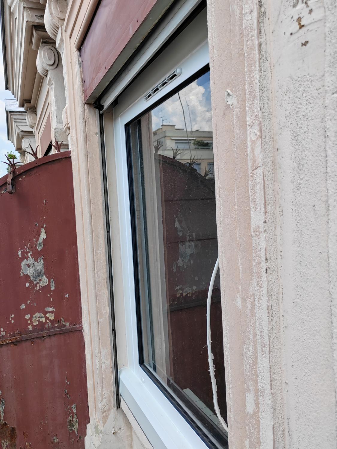 Fenêtre neuve calée dans un encadrement de pierre